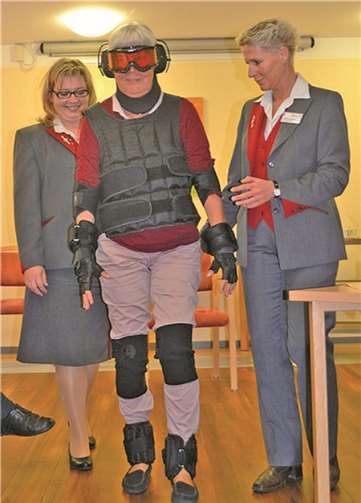 Unterstützt von Frau Schneider (r.) und Frau Steinbach (l.) wagt Frau Seebens die ersten Schritte mit dem Simulationsanzug. privat