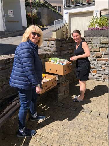 Ute Brachtendorf vom „Tragenden Netz“ überreicht die Lebensmittel der Tafel an die Familien Olfhevskyi und Pofapenko. Foto: Rudi Zenz