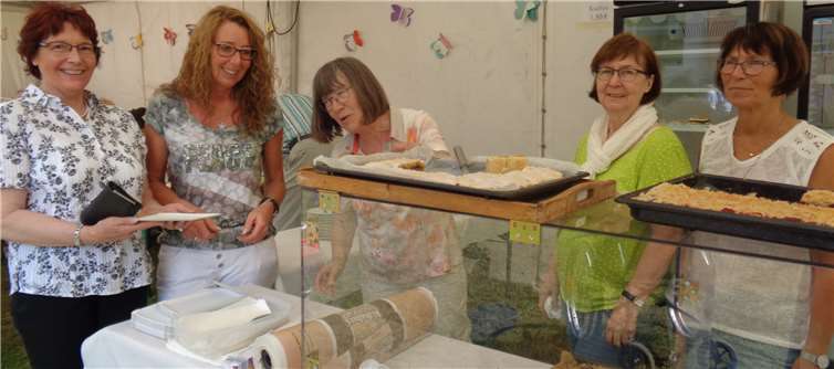 (V. r.) Die Helferinnen Brigitte Kassner, Christel Zerwas und Klara Heuft mit Gästen am Kuchenbuffet.