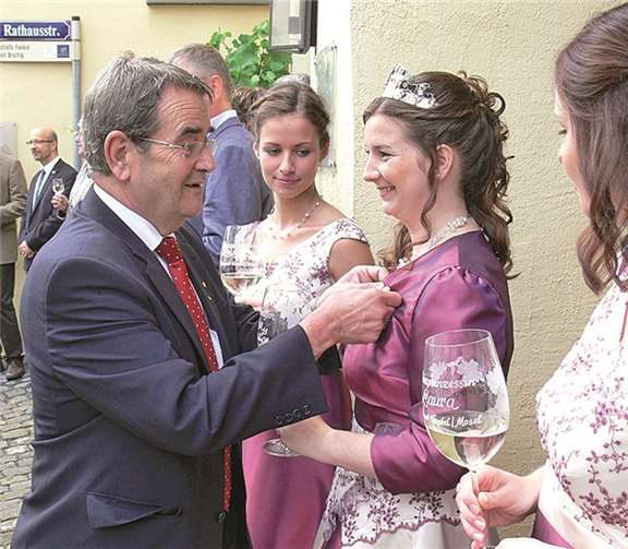 VG-Bürgermeister Helmut Probst stattete die drei neuen Weinmajestäten mit der goldfarbenen Mosel-Nadel aus.