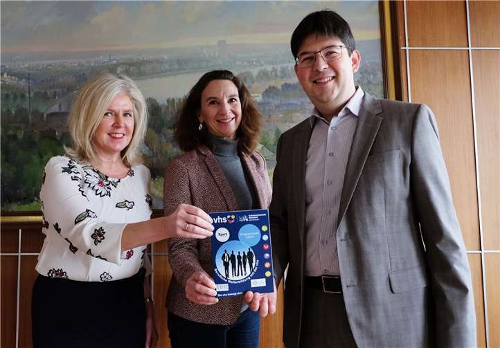 VHS-Verwaltungsleiterin Jutta Günther und die neue pädagogische Mitarbeiterin Kathrin Twiesselmann-Steigerwald überreichen Bürgermeister Michael Mang das neue Programmheft. Stadt Neuwied