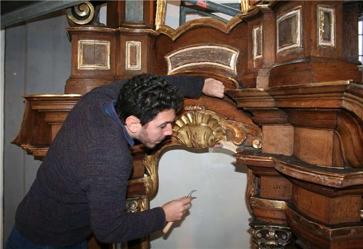 Valerio Di Finizio poliert mit einem Achatstein die Vergoldung.