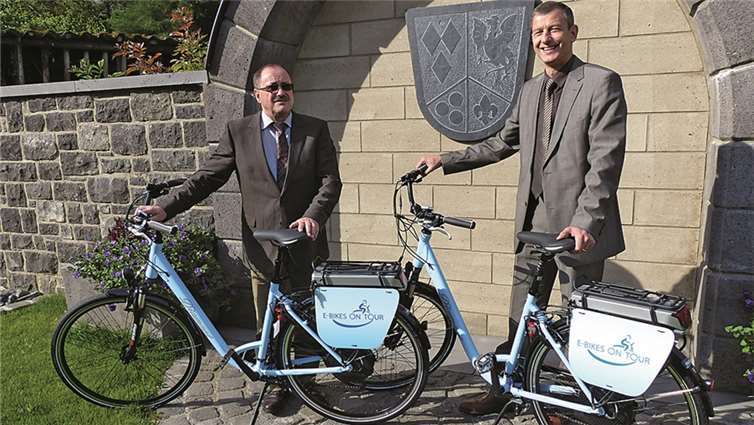 Verbandsbürgermeister Gerd Heilmann freut sich über zwei E-Bikes, die der Leiter der Region Rauschermühle bei RWE, Michael Dötsch (rechts) der Verbandsgemeinde überreichte.privat