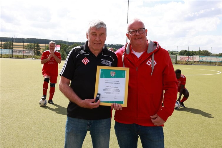 Vereinsvorsitzender Ludger Hoppe (r.) überreicht Uli Stukenbröker die Silberne Ehrennadel des Fußballverbands Rheinland.