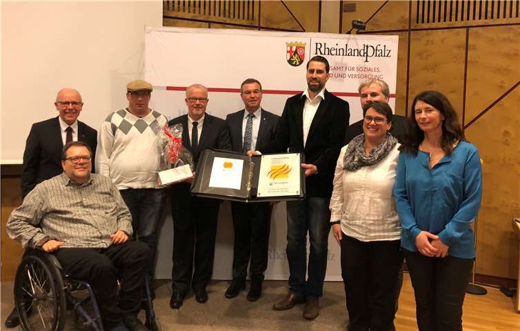 Verleihung des Landespreises für beispielhafte Beschäftigung für die Getränke Michel GmbH aus Bad Neuenahr-Ahrweiler: Seit drei Jahren beschäftigt der Betrieb von Geschäftsführer Michael Juchem (6. v. l.) den 38-jährigen Fabian Maagh (2. v. l.). Vertreter von Kreis, Caritas und Barmherzigen Brüdern gratulieren. Caritas Werkstätten