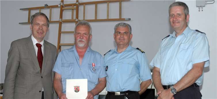 Verleihung des Silbernen Feuerwehr-Ehrenzeichens am Bande (v. l.): Bürgermeister Achim Haag, Brandmeister Winfried Marhöfer, Landesfeuerwehrinspekteur Hans-Peter Plattner und Wehrleiter Frank Linnarz. UM