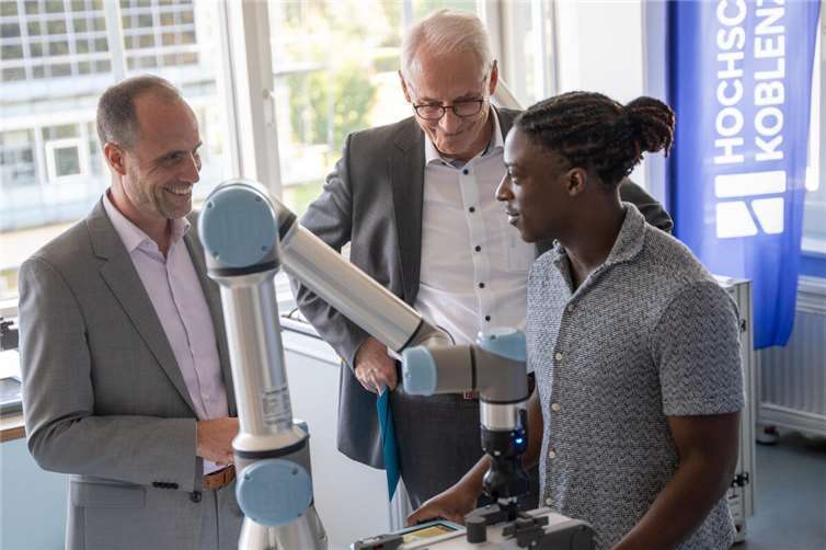 Hochschule Koblenz startet Studiengang für Robotik und KI Verschafft sich einen Eindruck vom Robotiklabor der Hochschule Koblenz: Wissenschaftsminister Clemens Hoch zum Start seiner Sommerreise 2025, hier mit Prof. Dr. Karl Stoffel, Präsident der Hochschule Koblenz und Fadou Ouro-Djeri, Student an der Hochschule Koblenz (v.li). Foto: Hochschule Koblenz/ Martin Lisek
