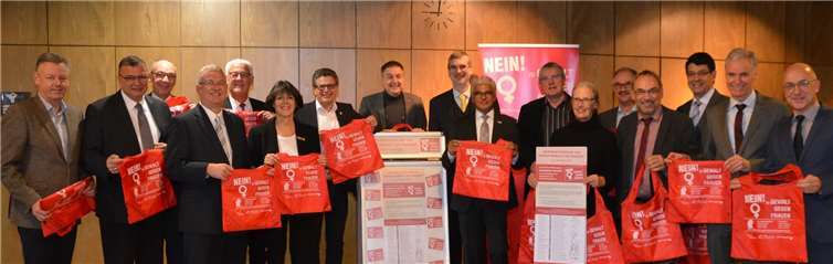 Verschiedene Bürgermeisterinnen und Bürgermeister sowie Vertreterinnen und Vertreter aus Politik und Verwaltung verteilen anlässlich des Internationalen Tages gegen Gewalt an Frauen in den Fußgängerzonen und Einkaufszentren der Region rote Taschen mit dem Slogan „Nein zu Gewalt gegen Frauen!“ Rhein-Sieg-Kreis
