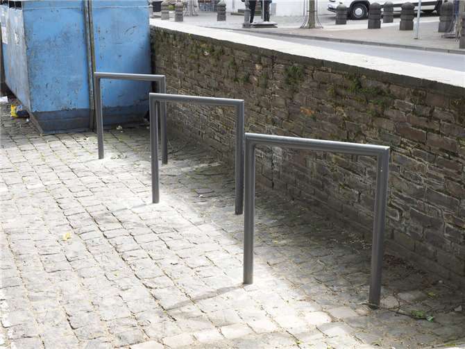 „Das kann doch wohl nicht wahr sein!?“ Versteckt hinter einer Mauer am Rande von Abfallcontainern (und deren Hinterlassenschaften / Glasresten und Müll) wurden drei Radbügel verankert. Foto: Hermann Schäfer