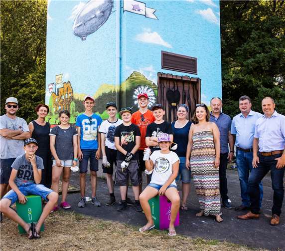 Vertreter der Stadt Ulmen, der Kreisjugendpflege Cochem, der JUKUSCH Cochem sowie der innogy stellten die bemalte Trafostation gemeinsam mit dem Graffiti-Profi GRIS und den jungen Künstlern der Öffentlichkeit vor. Foto: Kai Myller