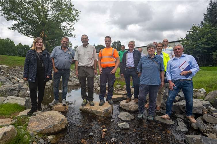 Vertreter von Behörden, Unternehmen und der Stadt Selters stehen im renaturierten Saynbach in Selters.