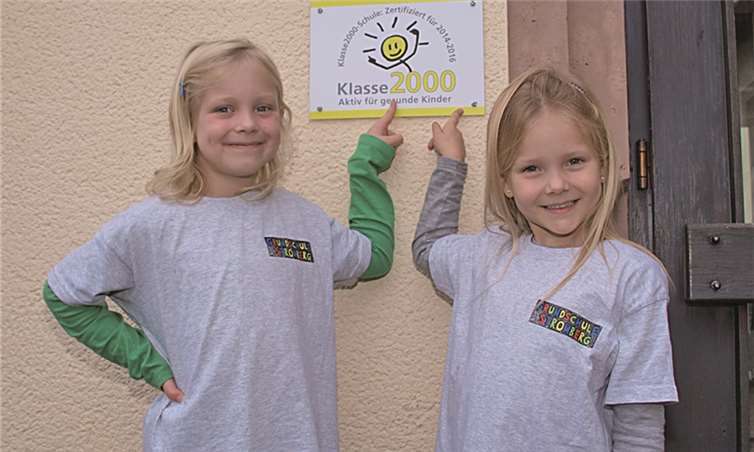 Viel Spaß hatten Noemi Kneip und Zoe Lay, als sie mit Stolz das Blechschild am Schuleingang mit dem Hinweis auf das erreichte Zertifikat zeigten. US