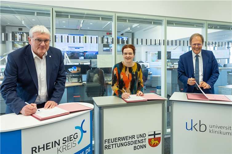 (V.l.: Landrat Sebastian Schuster, Bonns Oberbürgermeisterin Katja Dörner und Prof. Wolfgang Holzgreve, Ärztlicher Direktor des Universitätsklinikums Bonn (UKB), bei der Unterzeichnung der öffentlich-rechtlichen Vereinbarung für die Trägergemeinschaft für das gemeinsame Telenotarztsystem. Foto: Giacomo Zucca/Bundesstadt Bonn