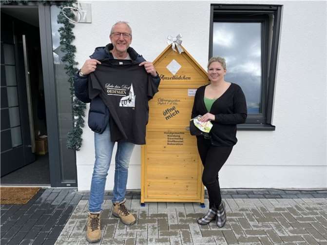 V.l. Nadine Schmahl & Olaf Wulf am „Amsellädchen“. Der neueste „Clou“ - ein T-Shirt pro Oedingen.  Foto: privat