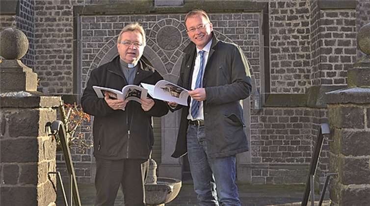 V.l.: Pastor Ralf Birkenheier und Bürgermeister Jörg Lempertz zeigen sich sichtlich beeindruckt von dem gelungenen Werk, welches sie druckfrisch vor der Kirche St. Cyriakus Niedermendig in den Händen halten. privat