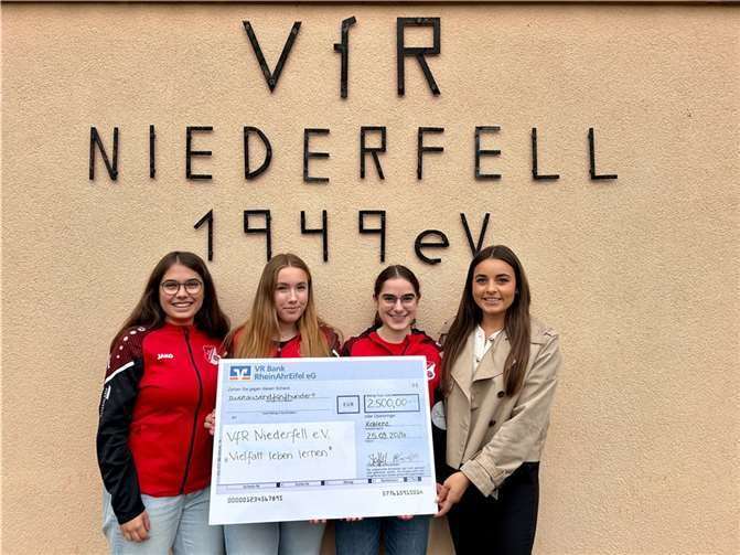 V.li. Carolin Boelkenius, Lotta Mönch, Sophie Boelkenius und Clara Elisa Stoffel (VR Bank RheinAhrEifel eG) bei der Scheckübergabe vor dem Vereinsheim in Niederfell. Foto: Nicole Tucker/VfR Niederfell e.V.