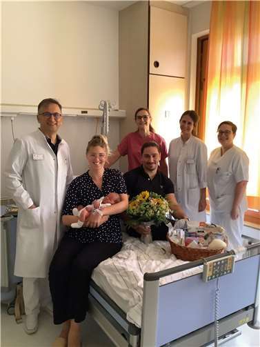 V.li. Chefarzt der Gynäkologie und Geburtshilfe Ilhan Saka überreichte in Begleitung von Hebamme Dunja Strahl, Assistenzärztin Saskia Wiacek und Kinderkrankenschwester Sarah Olligschläger den glücklichen Eltern einen Präsentkorb mit Blumenstrauß. Quelle: St. Nikolaus-Stifthospitals