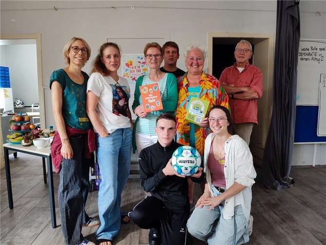 V.li. Sonja Wuttke, Phyllis Kohnen, Renate Adams, Patrick Book, Claudia Thelen, Rudi Kirwald und vorne: Teilnehmer Mino mit fairem Fußball und Pauline Krier. Foto: Nils/HoT