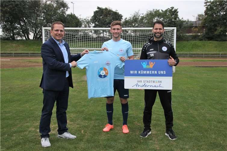 V.l.n.r.: Stadtwerke-Geschäftsführer Lars Hörnig, Mannschaftskapitän Leon Baumann und Salvatore Nizza (Trainer-A-Junioren SG 99 Andernach), freuen sich über die Partnerschaft bei der Trikotübergabe mit dem Motiv der Hafen-Kampagne „Think Trimodal“.