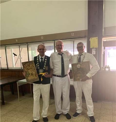 Vogelkönig Henry Meyer, Brudermeister Hartmut Steinwedel und Scheibenkönig Winfried Weinand, beide mit ihren geschnitzten Präsenten, die Motive aus der Mendiger Tradition zeigen (v. l.).