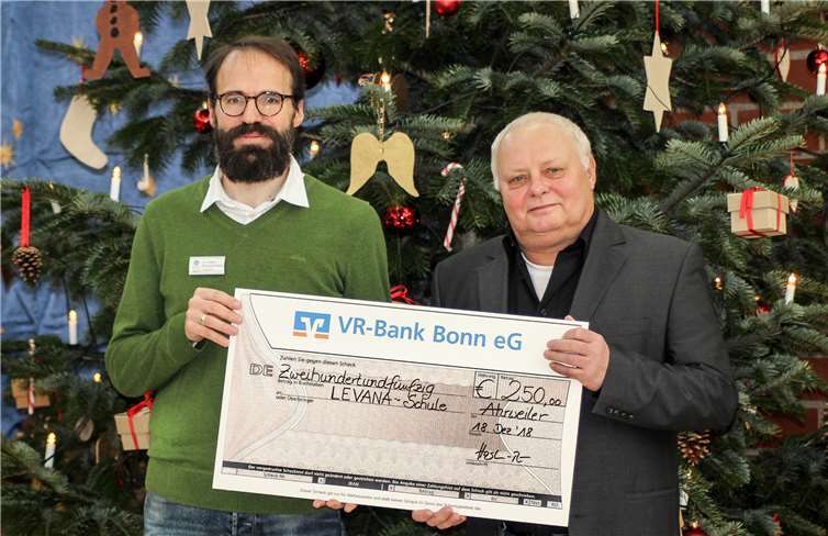 Volker Hostert-Riemenschneider und Steffen Hudasch bei der Scheckübergabe vor weihnachtlicher Kulisse.Ingo Görres