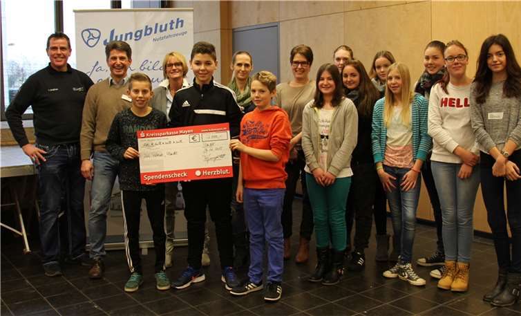 Volker und Toni Jungbluth, Schulleiterin Martina Backmann sowie Tina Foroutan vom Musicalverein und Marion Wicha vom Förderverein der Schule zusammen mit einigen Musicalakteuren und Schülern und Schülerinnen (v.l. hinten) bei der Scheckübergabe.