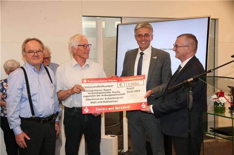 Voller Freunde konnte Heinz Lempertz (2.v.l.) für die Kulturgemeinschaft Albertinum den fehlenden Geldbetrag von der Sparkasse entgegennehmen, um die von Leonhard Fuchs (l.) gespendeten Mühleine im Hof Michels in Mendig aufstellen zu können