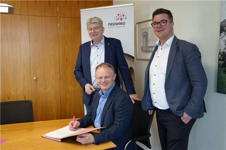 Vollständig und unterschrieben: Die Stadt Neuwied hat die Unterlagen zum PEK-Programm beim Land eingereicht. Oberbürgermeister Jan Einig (sitzend), Bürgermeister Peter Jung (rechts) und Beigeordneter Ralf Seemann freuen sich, dass die Stadt damit ihre Hausaufgaben gemacht hat und in Kürze einen 25-Millionen-Euro-Schuldenschnitt erwarten kann.  Foto: Stadt Neuwied / Maxie Meier