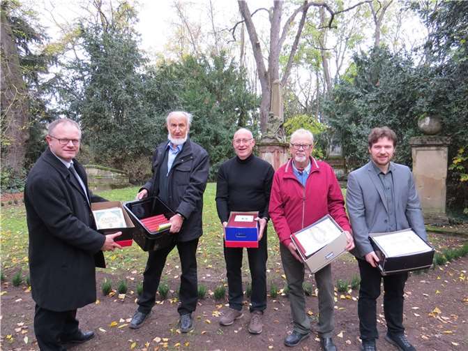 Vom privaten Fundus ins Stadtarchiv: Hans-Joachim Feix (Zweiter von links) überreichte seine Büchersammlung auf dem Alten Friedhof an Stadtarchivar Bernd Breidenbach (rechts). Auch OB Jan Einig (links), K.D. Boden (Mitte) und Horst Ueding (Zweiter von rechts) halfen mit. Foto: Stadt Neuwied