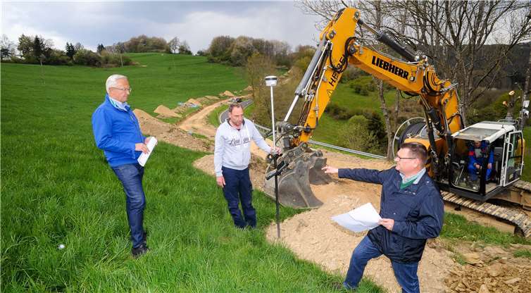 Von Spreitchen bis zur Ortslage Reifert läuft derzeit die unübersehbare Baustelle.Die Arbeiten gehen gut voran, wie Landrat Achim Hallerbach (l.) undStadtwerke-Geschäftsführer Stefan Herschbach (r.) sahen. Axel Urmetzer von denSWN erläuterte, wie präzise die digitale Technik inzwischen arbeitet, um dieBaustelle genau zu vermessen.