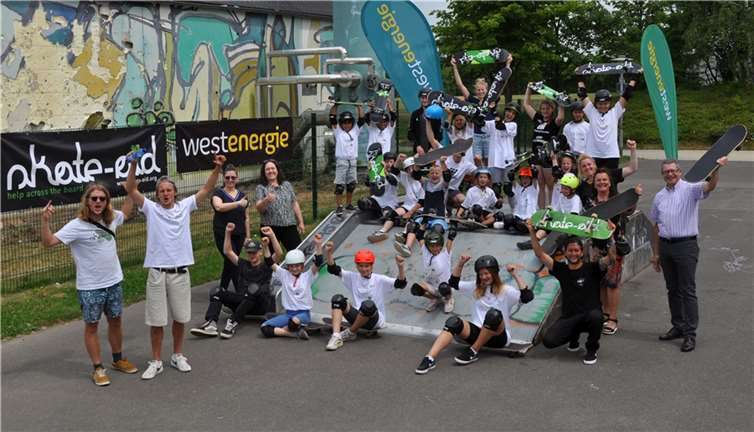 Von der ausgelassenen Stimmung auf der Skateranlage am Schulcampus lassen sich auch der Erste Beigeordnete Hans Dieter Wirtz (rechts) und die Kommunalbetreuerin des Kommunalen Partnermanagements bei Westenergie Lydia Bauer (2.v.r.) anstecken. Foto: Stadt Meckenheim