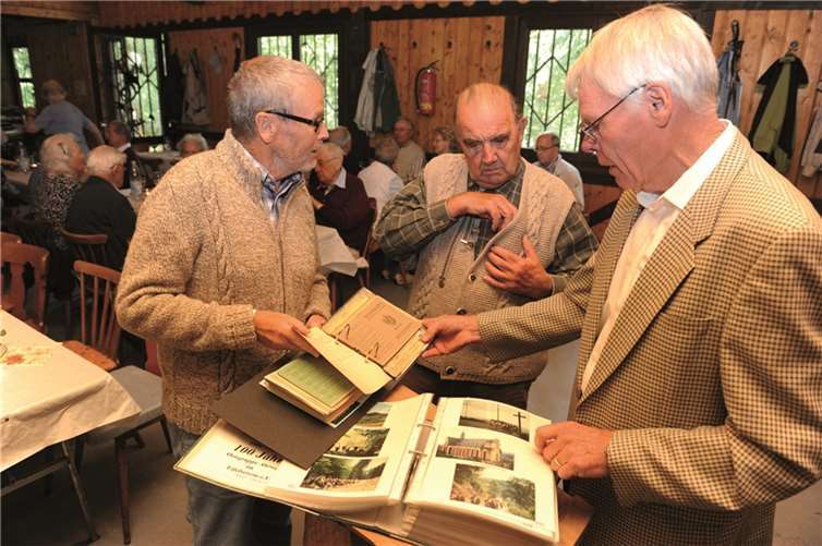 (Von links) Günter Frömbgen, Reiner Jakobs und der Vorsitzende Heinz Ahrendt schmökerten im alten Wander- und Fotobuch.