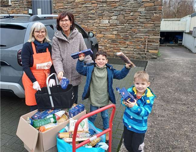 (Von links) Manuela Schönfeld von der Tafel und Kita-Leiterin Heike Neumann-Dittrich freuen sich mit zwei Kindergartenkindern über die Lebensmittelspende für die Caritas-Tafel, Resultat der St. Martinsaktion der Kita Löwenzahn in Andernach.  Foto: Stefanie Gemein