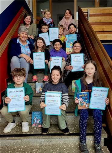 Von unten nach oben, von links nach rechts: 1. Reihe: Ilyas Krenz, 2. Platz/ Anastasia Dimarchopoulou, 1. Platz / Svenja Gebhardt, 3. Platz - 2. Reihe: Rektorin Anjo Närdemann/ Theresa Bucher/ Mahir Arslan/ Jenna Suliman, Sonderpreis der Jury - 3. Reihe: Ute Gebhardt, Büchereiteam / Tim Juchem / Anton Hoffmann / Evrem Mert Tekin - 4. Reihe: Monika Gemmerich, Leiterin Büchereiteam der GS / Silvia Berger, Büchereiteam.  Foto: GS St. Martin Remagen