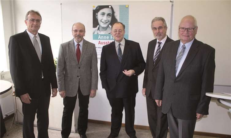 Vor dem Ausstellungsfoto von Anne Frank umgaben Landrat und Schulleiter, Stadtbürgermeister und der 2. Vorsitzende des DIF den Gastredner Rudolf Dreßler bei der Eröffnungsfeier in der Alice Salomon Schule. DL