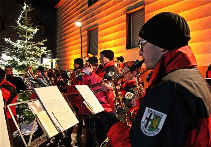 Vor dem Heimathaus erfreuen die Musiker ihr Publikum mit weihnachtlichen Klängen. Fotos: Privat