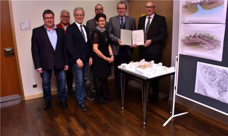 Vor dem Modell der Kita Wildburg und Planungen für die Rheinanlagen freuen sich Kommunalpolitiker und Abgeordneter über den Förderbescheid. Fotos: HEP