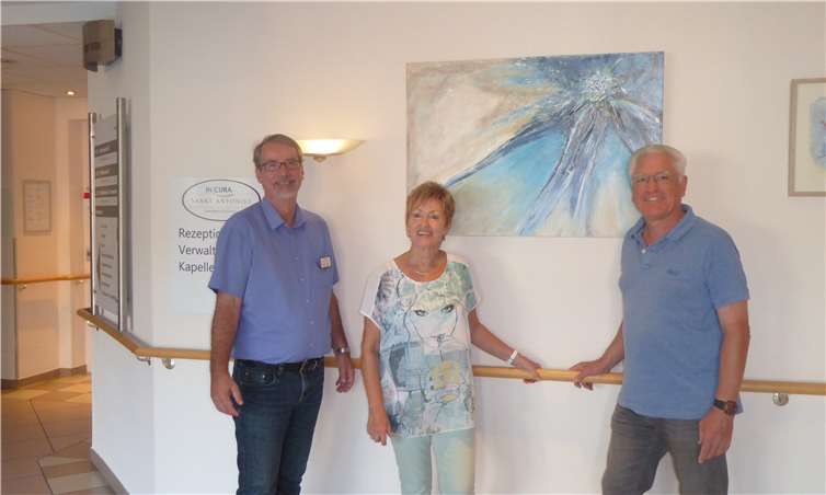 Vor dem Titelbild der Ausstellung Einrichtungsleiter Sven Lefkowitz mit den Künstlern Gretel Kiesewetter und Wolfram Sauerbrei (v.l.). Privat