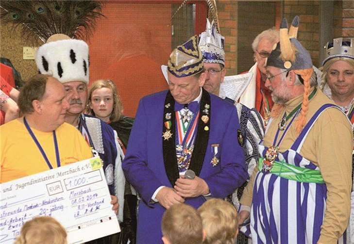 Vor dem amtierenden Merzbacher Dreigestirn - Bauer Karl-Heinz (Schönenberg), Prinz Andreas I. (Mirbach), Jungfrau Thomina (Thomas Jäckel) - überreichten Schatzmeister der KJI, Hans-Peter Kreische (links) und Kalle Kerstholt (rechts) dem Vereinspräsidenten Peter Lanzrath einen Scheck in Höhe von 1.000 Euro zur Unterstützung der Kinder- und Jugendarbeit der Karnevalsfreunde Merzbach/Neukirchen.Privat