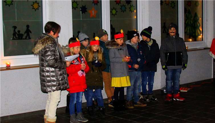 Vor dem beleuchteten Adventsfenster trugen die Schüler der Klasse 3a Lieder und Texte vor. Foto: privat