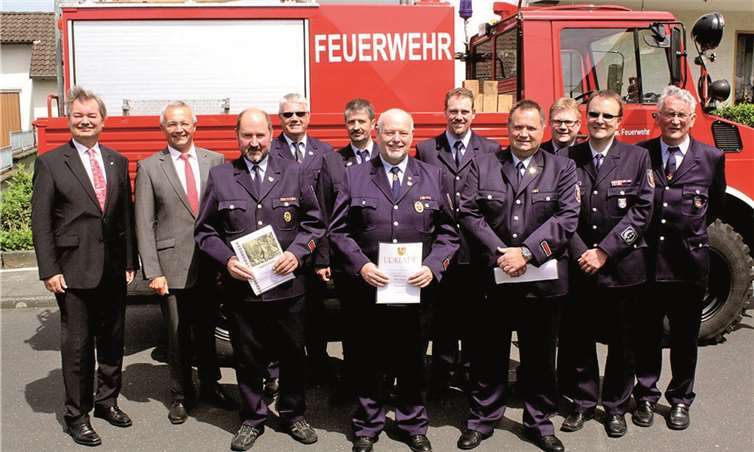 Vor dem instand gesetzten TLF stellen sich die ausgezeichneten Feuerwehrleute mit den Offiziellen auf.DL