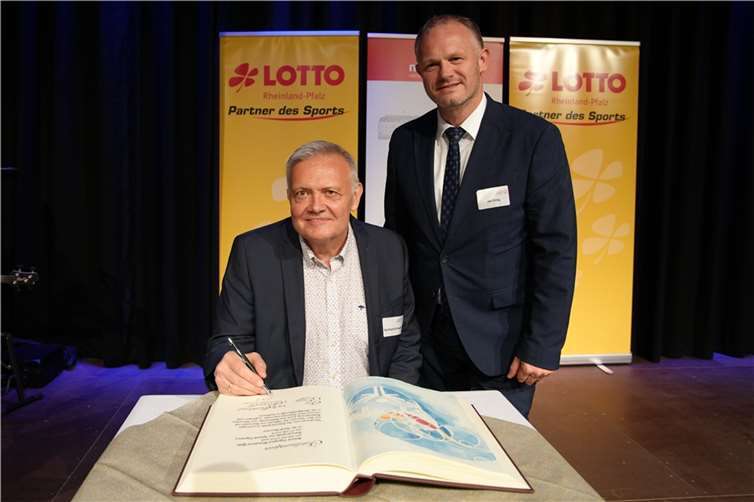 Vor den Augen aller Gäste trug sich Special Olympics Präsident Burkhard Schappert auf der kunstvoll gestalteten Seite ein.  Foto: Melanie Lange