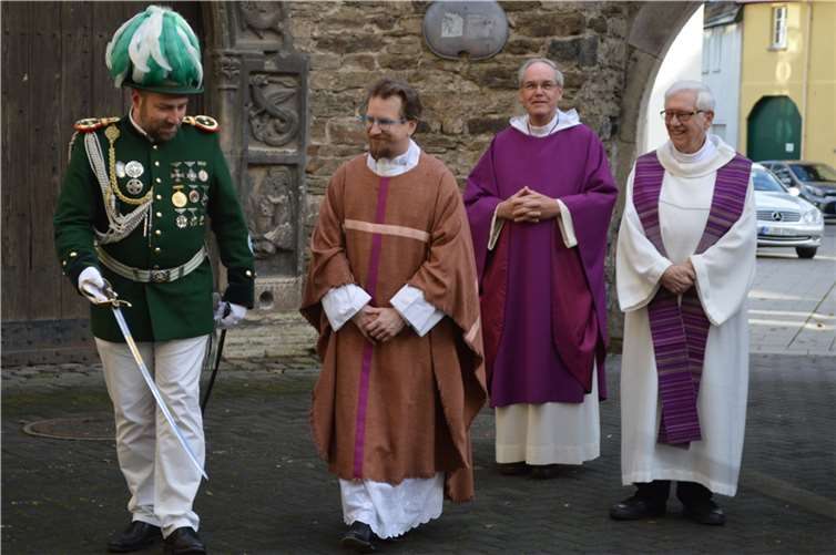 Vor der Kirche mit Begleitung durch die Schützen: Pfarrer Heiko Marquardsen mit den Konzelebranten. Fotos: AB