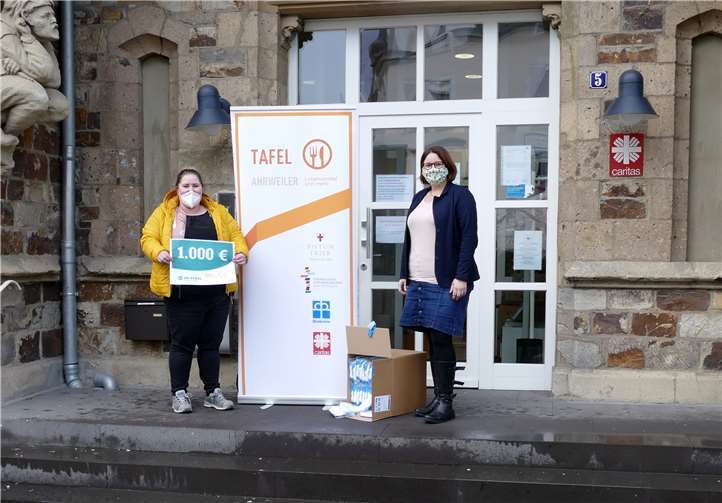 Vor der Kulisse des schönen alten Bahnhofs Ahrweiler, dem örtlichen Sitz der Caritas, konnte Klara Eckel (links) den symbolischen Scheck zusammen mit 200 FFP2-Masken für die Mitarbeiter und Helfer an Christiane Böttcher (rechts) überreichen.. Foto: privat