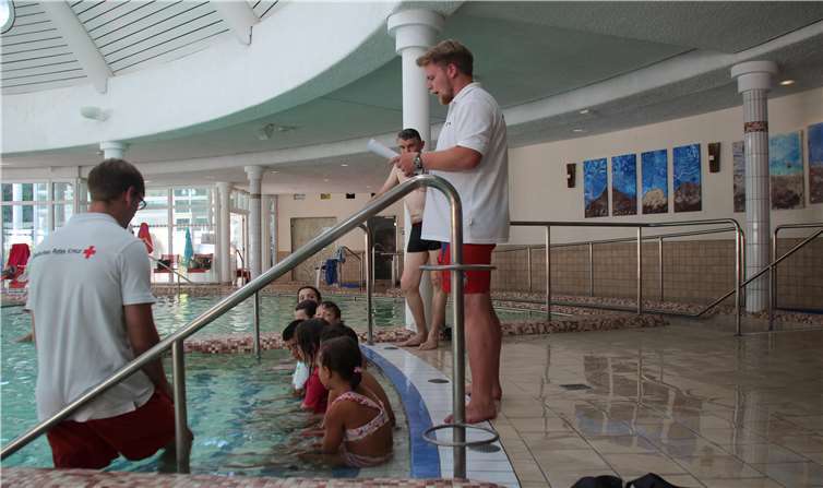 Warum es so wichtig ist, dass unsere Jüngsten schwimmen lernen Vor der Praxis die Theorie: die Kinder hören SchwimmausbilderAlexander Zuber (links) und Assistent Julian Ott (rechts)von der DRK-Wasserwacht aufmerksam zu. Fotos: KMI