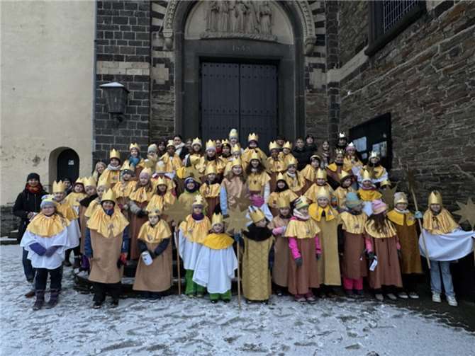 Vor der Sankt Arnulf Pfarrkirche sind zur Aussendung die Sternsinger mit ihren Betreuenden versammelt. Foto: Simone Nonn