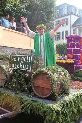 Vor dicken Weinfässern stehend, die er am Unkeler Pütz mit „Rotem“ gefüllt hatte, grüßte Bacchus sein weinseliges Völkchen beim Festzug.