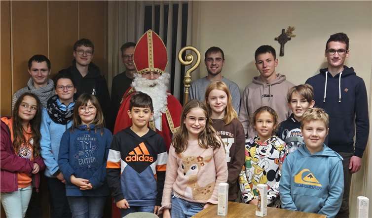 Vordere Reihe: Lotte Spiller, Malina Meid, Emma Mittler, Kilian Hilger, Marlene Nonn, Kiara Wohlleben, Mirijam Hackenbruch, Adrian Neumann, und Moritz Sieben, und hintere Reihe Benedikt Lohner, Jonas Lindemann, Pastor Norbert Missong, der heilige Nikolaus, Lukas Lindemann, Finn Peters und Leonard Schütz. Foto: Raphael Weber