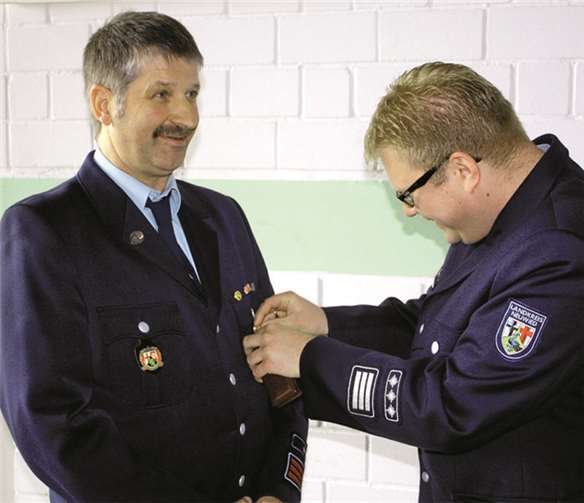 Vorsichtig heftet der stellvertretende Kreisfeuerwehrinspekteur dem Orsberger Dieter Rosen das Ehrenzeichen in Gold an.