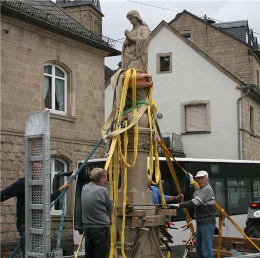 Vorsichtig wurde die restaurierte Mariensäule mittels eines Traktors vom Vereinsgelände zum endgültigen Standort gebracht.WER
